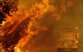 A fire truck drives through flames as the Hennessey fire continues to rage out of control near Lake Berryessa in Napa, California on August 18, 2020.