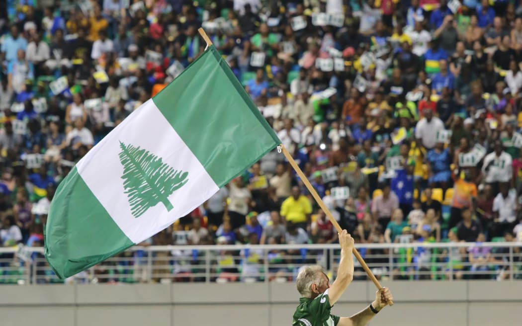 A lone flag bearer represents Norfolk Island at the 2023 Pacific Games.
