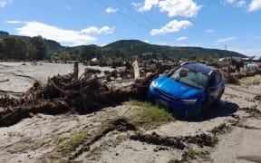 Damaged vehicles, broken powerlines and piles of silt line State Highway 5 in Esk Valley, after Cyclone Gabrielle.