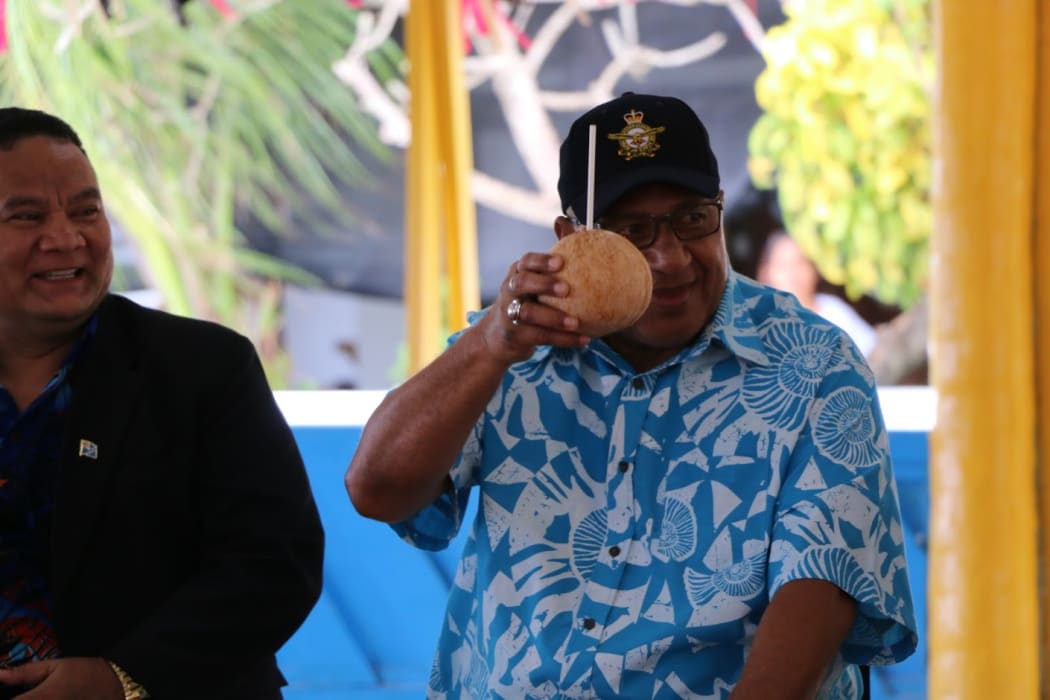 Fiji's prime minister, Frank Bainimarama, raises a coconut on his arrival in Tuvalu for the 2019 Pacific Islands Forum summit.