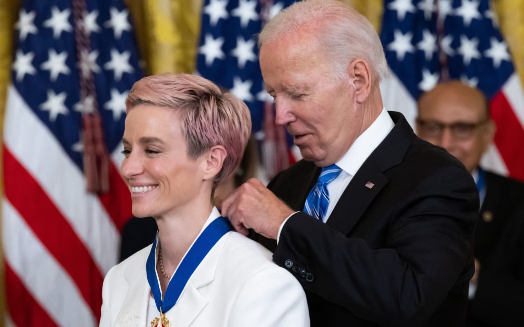 US President Joe Biden presents US soccer player Megan Rapinoe with the Presidential Medal of Freedom, the nation's highest civilian honor, during a ceremony honoring 17 recipients, in the East Room of the White House in Washington, DC, July 7, 2022. - The Suit of US soccer player Megan Rapinoe is embroidered with the initials 'BG', for WNBA player Brittney Griner, who is held in Russia (Photo by SAUL LOEB / AFP)