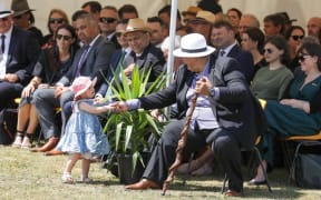 Prime Minister Jacinda Ardern's daughter Neve Te Aroha Gayford plays at the feet of those sitting near the pae.