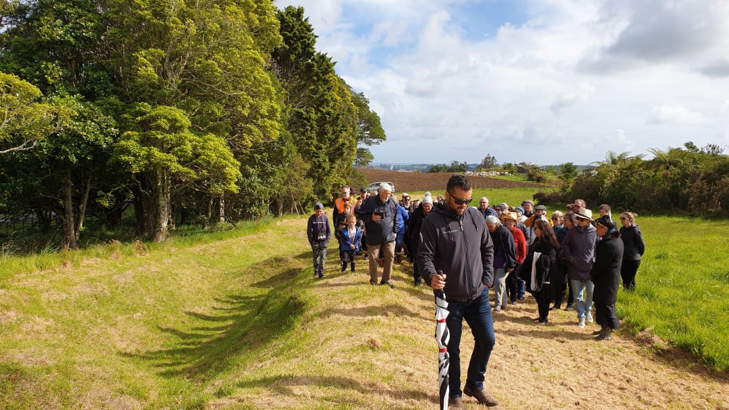 Pukerangiora hapū member Anaru White guides a group on the slopes of the site.