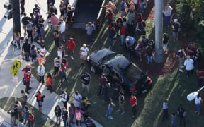 People wait for loved ones as they are brought out of the Marjory Stoneman Douglas High School after the shooting.