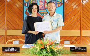Cristelle Pratt (left) accepts the cheque from Herman Chiu.