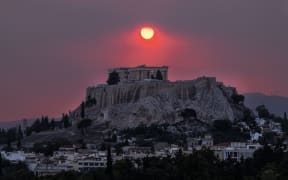 Smoke rises over the Acropolis Hill and the Parthenon from a wildfire that is burning at the western suburbs of the city of Athens, on August 22, 2023 (Photo by Andrea Bonetti / SOOC / SOOC via AFP)