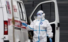 Patients suspected of Covid-19 infection are brought by health officials wearing protective gear with ambulances to Kommunarka Hospital in Moscow, Russia