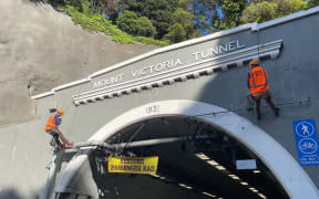 Two protesters from the Restore Passenger Rail group have abseiled down the Hataitai side of the Mt Victoria Tunnel in Wellington and hung a sign saying 'Restore passenger rail'.