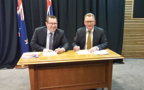 Finance Minister Grant Robertson and RBNZ governor designate Adrian Orr sign a new policy agreement.