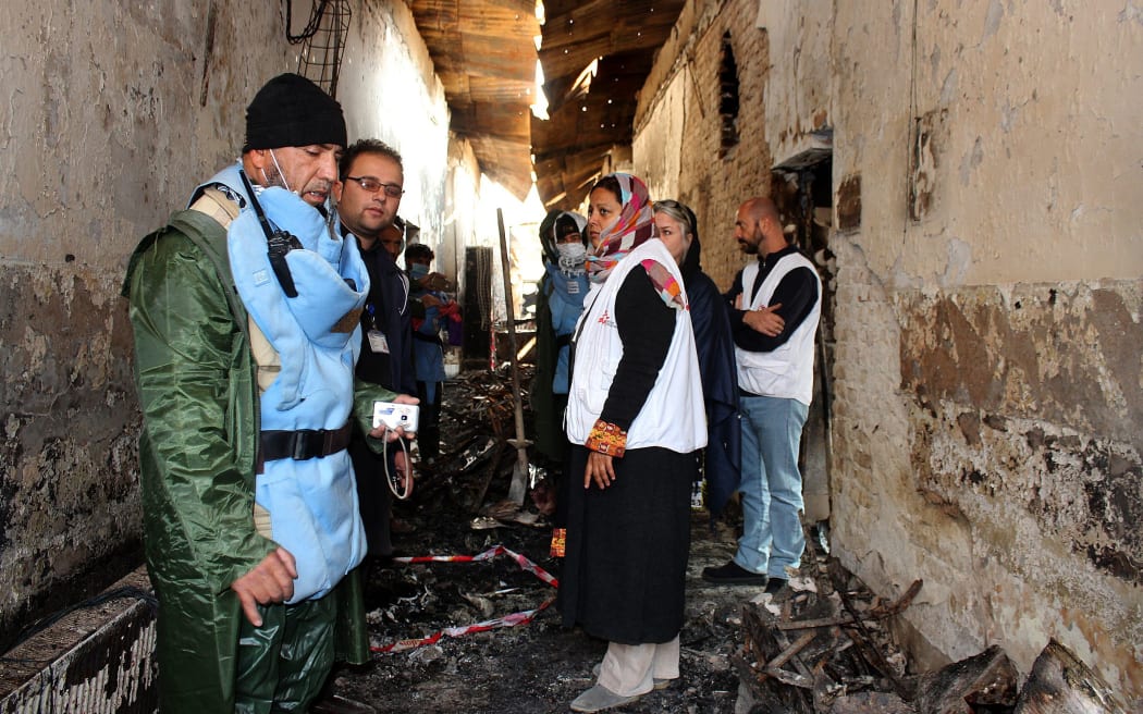 November 10 ,2015, an Afghan (L) talks to staff members in a charred corridor of the damaged Medecins Sans Frontieres (MSF) hospital in northern Kunduz. On October 3, 2015 US forces bombed the MSF Hospital in northern Kunduz, killing at least 30 people.