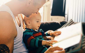 Father reading to baby son