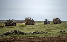 A joint Russian (dark vehicles) and Turkish (light brown vehicles) convoy patrols in oil fields near the town of al-Qahtaniyah, in Syria's northeastern Hasakeh province close to the Turkish border, on February 4, 2021.