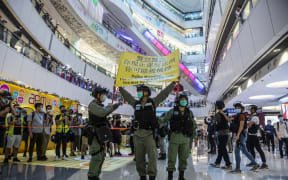 Riot police hold up a warning flag during a demonstration in a mall in Hong Kong on July 6, 2020, in response to a new national security law.