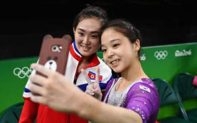 Lee Eun-ju of South Korea and Hong Un-jong of the North pose for a photo together.