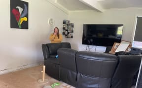 Nicola Farley in her flood-damaged lounge in the house she can no longer live in.