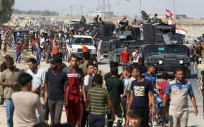 Civilians gather as Iraqi forces arrive in the southern outskirts of Kirkuk.