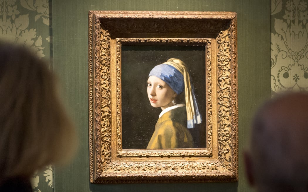 Besucher betrachten das Gemälde von Johannes Vermeer "Frau mit Perlenohrring" im Mauritshuis in Den Haag, 27. Oktober 2022. – Die niederländische Polizei verhaftete drei Personen, nachdem Klimaaktivisten das Gemälde von Johannes Vermeer angegriffen hatten "Frau mit Perlenohrring".