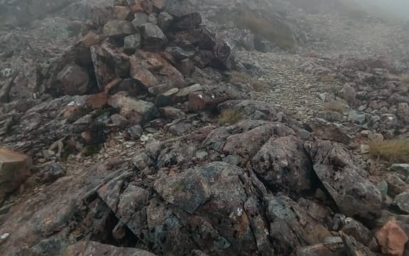 An image of a rock cairn, high on a ridge line, very useful for identifying the trail.
