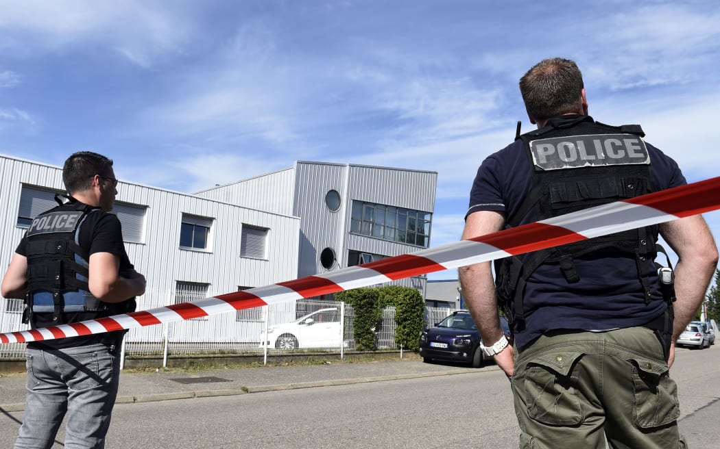 French police officers stand guard near a cordon outside the Colicom delivery service company in Chassieu near Lyon.