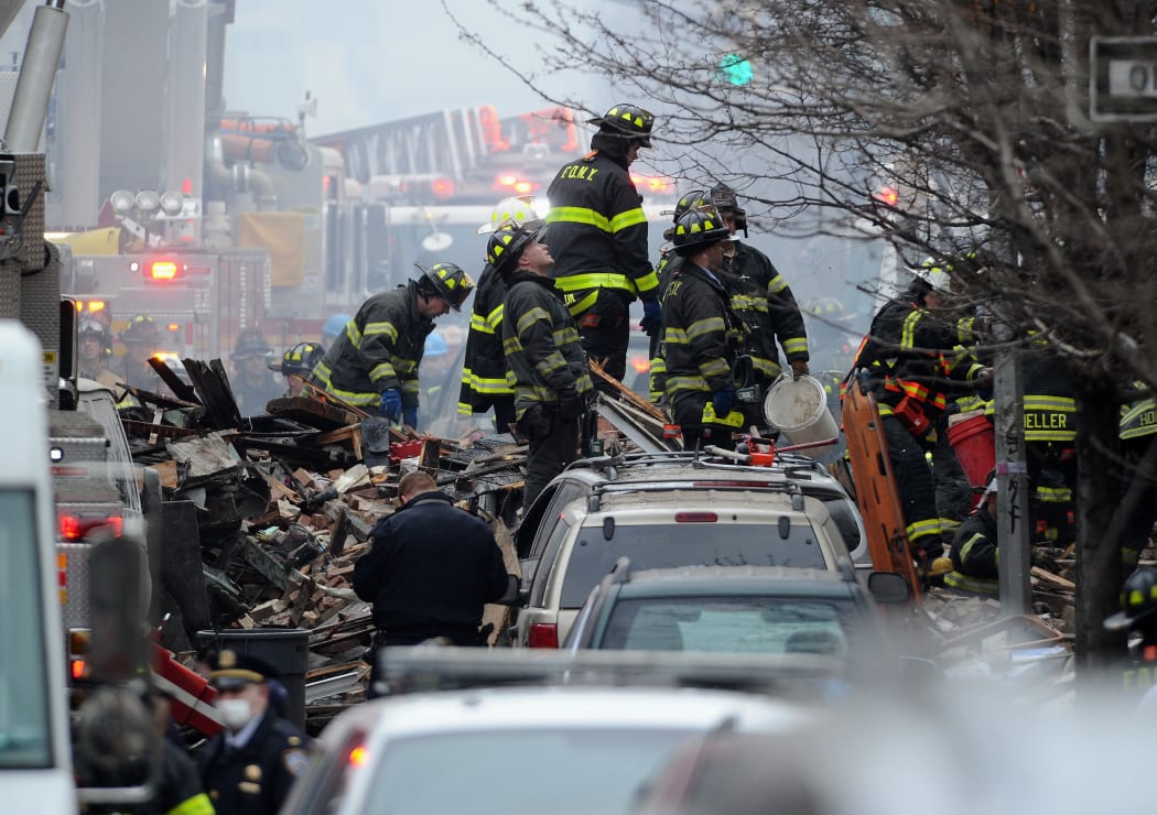 New York City firefighters on a pile of debris at the scene.