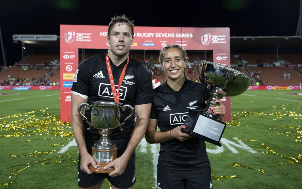 All Blacks sevens co-captain Tim Mikkelson and Black Ferns sevens captain Sarah Hirini with their trophies from the Hamilton Sevens . 2020.