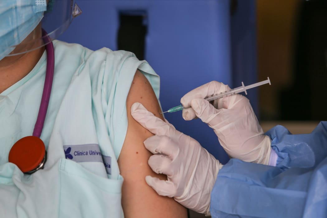 A healthcare worker injects a dose of the Pfizer-BioNTech Covid-19 vaccine to an emergency doctor in Colombia on February 18, 2021.