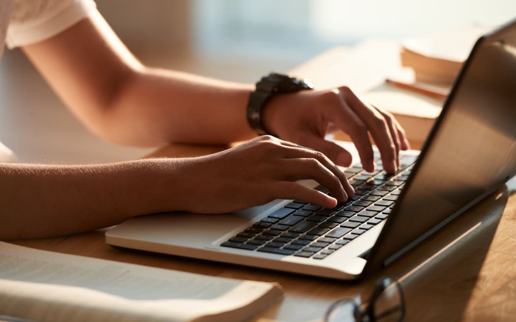 Hands of person typing on laptop keyboard