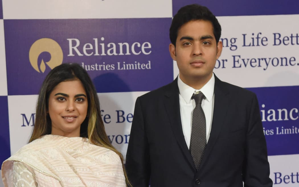 India's richest man and oil-to-telecom conglomerate Reliance Industries chairman Mukesh Ambani's children Isha (L) and Akash arrive for the company's 41st AGM in Mumbai on July 5, 2018. India's oil-to-telecom conglomerate Reliance Industries, recorded standalone net profit of 86.97 billion rupees for the quarter ended March 31 from 81.51 billion rupees a year earlier, for its oil, refining, and petrochemicals businesses. (Photo by Indranil MUKHERJEE / AFP)