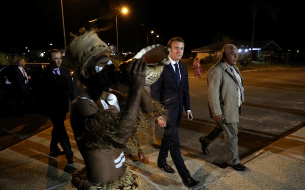 French President Emmanuel Macron (C) walks with President of the 'Senat Coutumier' Pascal Sihaze (R) and others as he arrives to attend a welcoming ceremony at The Coutumier Senate in Noumea on May 3, 2018.