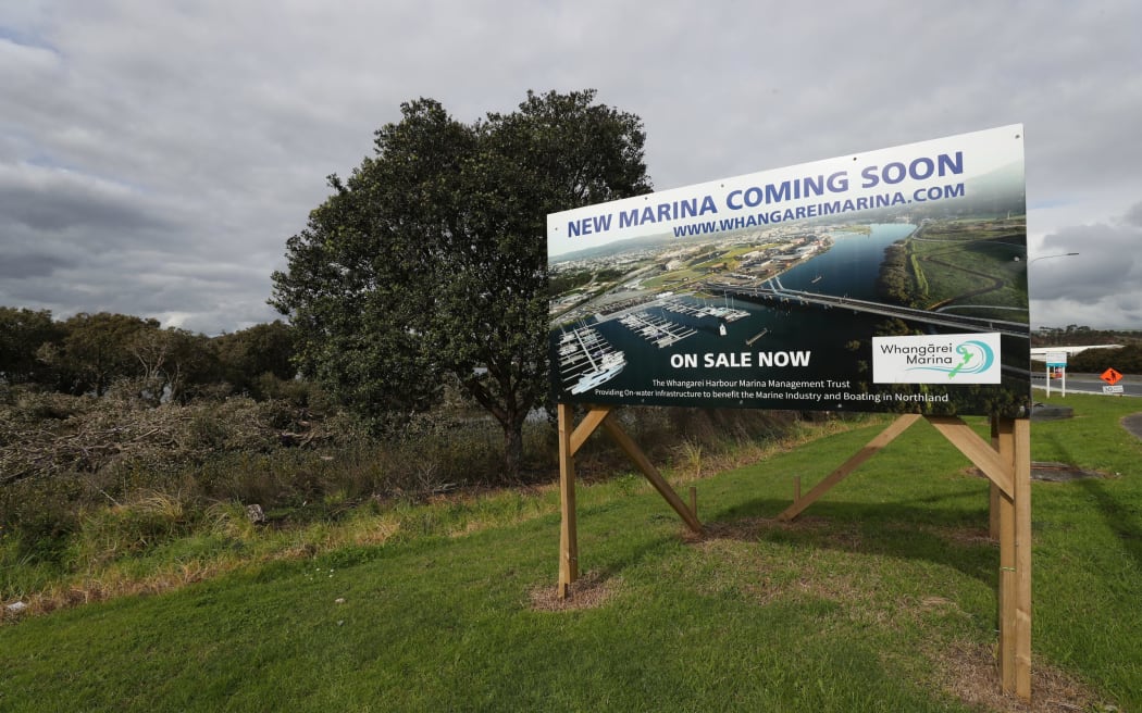A sign of the times alongside the Port Road mangrove forest which is the site of the new Okara marina.
