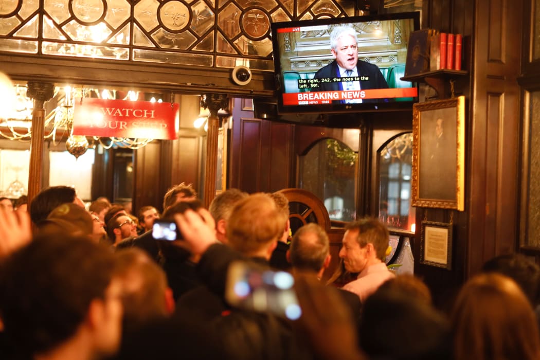 Pubgoers watch a television screen in Whitehall as John Bercow, Speaker of the House declares that Prime Minister Theresa May's Brexit deal was defeated by 149 votes in an historic parliamentary vote on March 12, 2019.
