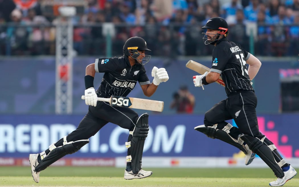Daryl Mitchell (R) and Rachin Ravindra of New Zealand run between the wicket during the ICC Men's Cricket World Cup India 2023 match between India and New Zealand
