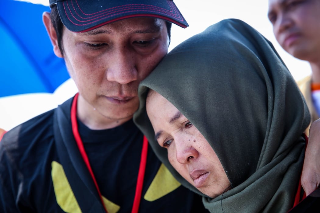 Families and colleagues of passengers and crew of Lion Air flight JT610 pray and cry on the deck of Indonesia Navy ship KRI Banda Aceh as they visit the site of the crash to pay their tribute, at the north coast of Karawang, Indonesia, on Tuesday, November 6, 2018.