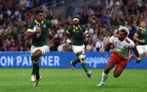 South Africa's centre Canan Moodie runs with the ball to score a try as Tonga's wing Fine Inisi  attempts to intercept during the France 2023 Rugby World Cup Pool B match between South Africa and Tonga at Stade Velodrome in Marseille, south-eastern France, on October 1, 2023.