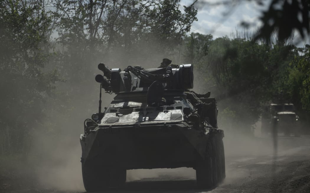 Ukrainian servicemen ride on armoured personnel carriers (APC) on a road toward Bakhmut, Donetsk region, on July 1, 2023, amid the Russian invasion of Ukraine. (Photo by Genya SAVILOV / AFP)