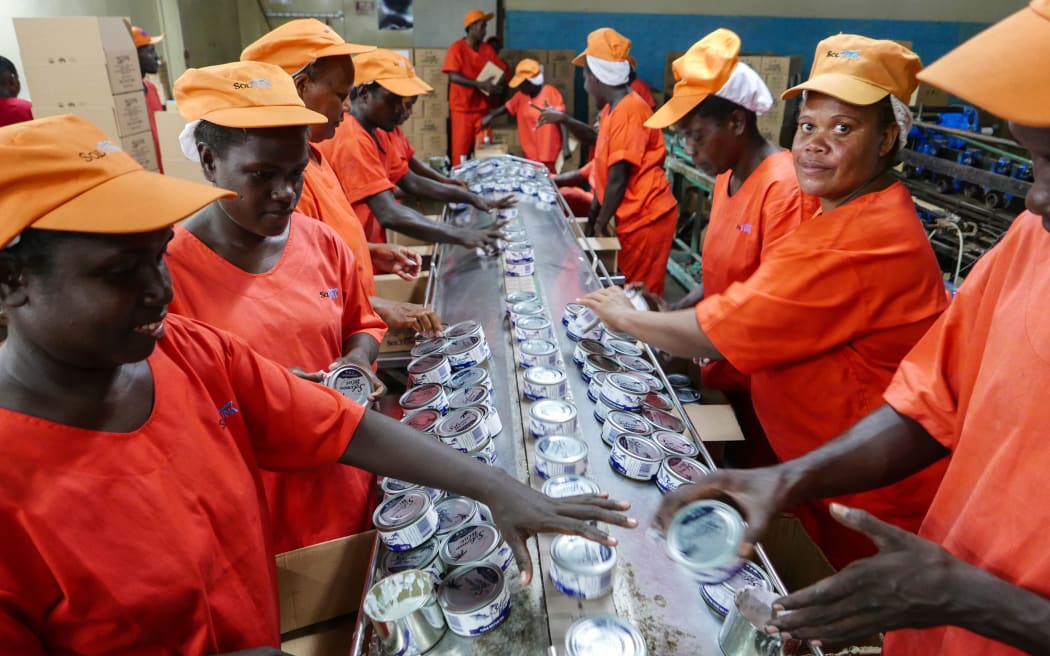 Étiquetage et emballage de boîtes de Soltuna produites localement à Noro, Îles Salomon.