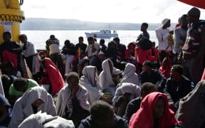 This handout picture taken and released by the Italian Red Cross on October 22, 2016 shows migrants landing in Vibo Marina, after a rescue operation in the Mediterranean Sea.