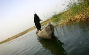 A veiled Iraqi woman rides in a boat as she goes out fishing early morning in marshland near Karbala, 110km south of Baghdad, in 2006.