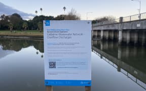 A sign erected on the banks of the Taruheru River, in the middle of the city, says untreated wastewater discharges might occur at this location in heavy rain events.