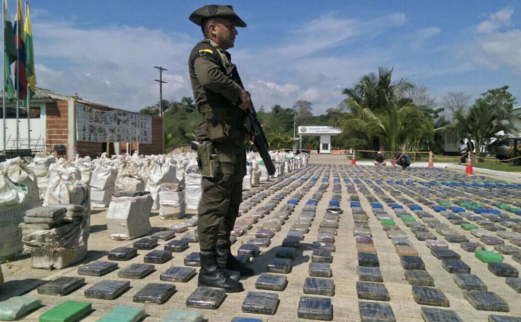 A Colombian police officer standing guard over eight tons of seized cocaine in Turbo, Antioquia department, on May 15, 2016.