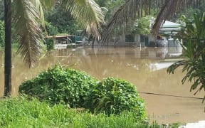 Flood waters threaten a house at Tupapa, Rarotonga.