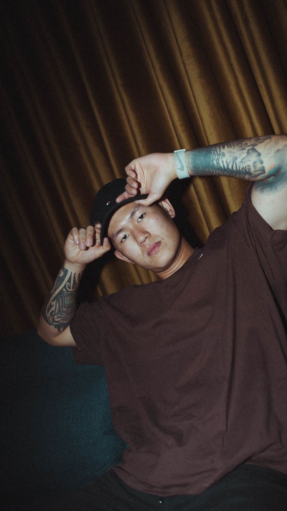 EDY poses in moody lighting touching his hat