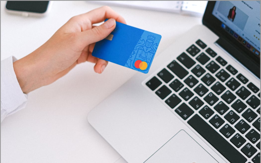 Woman using credit card with laptop