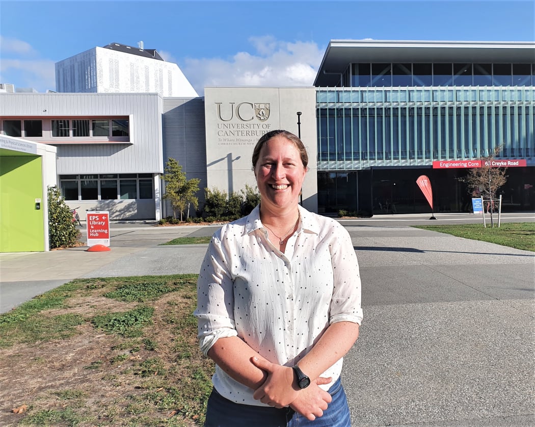 Sarah Kessans from the University of Canterbury stands in front of a University building.
