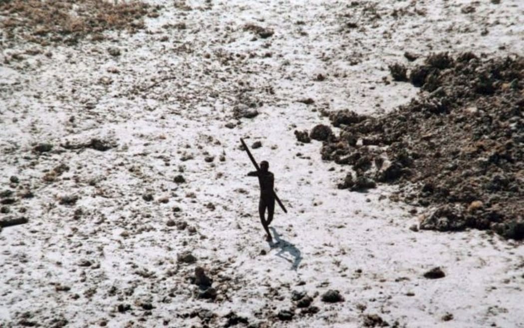 Few images exist of the Sentinelese people. In this picture taken in 2004, a man from the tribe aims a bow and arrow at an Indian Coast Guard helicopter as it flies over North Sentinel Island.