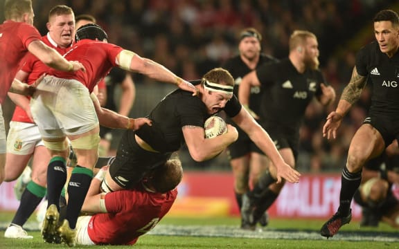 All Black Brodie Retallick is tackled by British and Irish Lions player Alun Wyn Jones