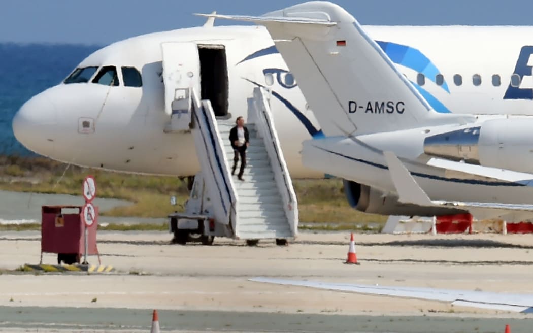 A man believed to be the hijacker of the EgyptAir Airbus A-320, which was diverted to Cyprus, leaves the plane before surrendering to security forces after a six-hour standoff.