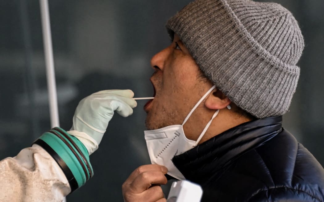Un operatore sanitario preleva un campione di tampone da un uomo da testare per il coronavirus Covid-19 in un ospedale di Pechino il 26 dicembre 2022.