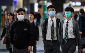 Young students wear face masks in the arrivals hall at Hong Kong's international airport on January 22, 2020.