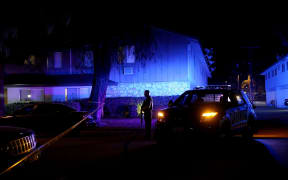 A police officer stands guard during an investigation of a suspicious vehicle on 2 December in Redlands, California.
